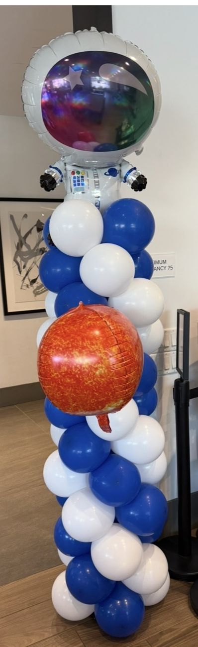 Blue and white balloon column topped with an astronaut