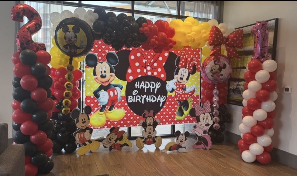 Mickey and Minnie birthday with red, black and yellow balloon garland, columns and character cutouts