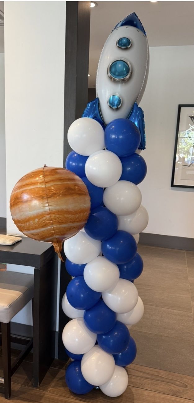 Blue and white balloon column topped with a rocket
