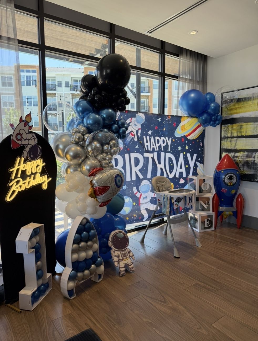 Space-themed first birthday with balloon garland, neon sign and marquee number 1
